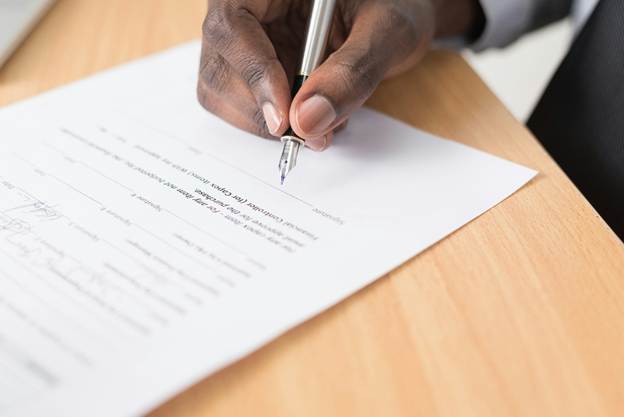A person signing a document

AI-generated content may be incorrect.